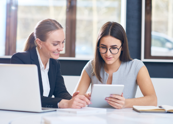 two women using laptop computer 